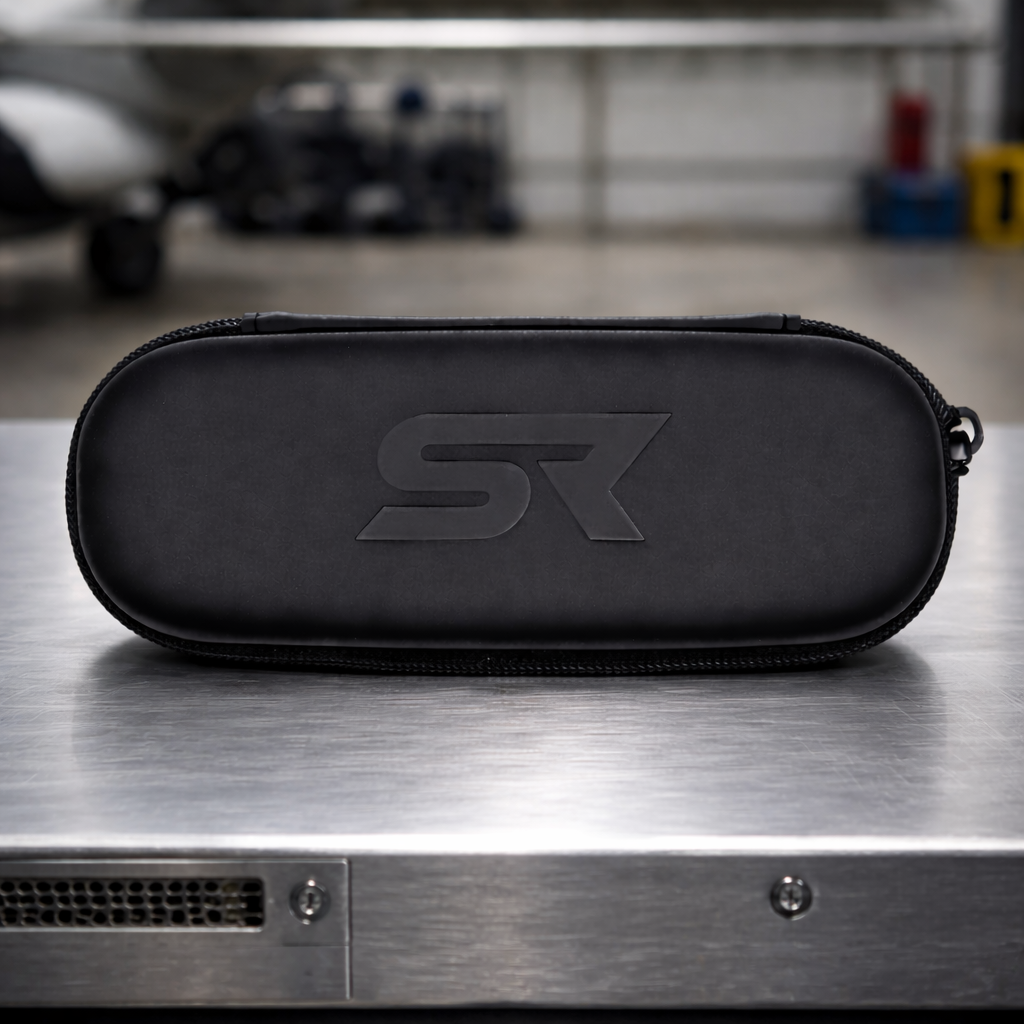 SkyRift SR protective sunglasses case with embossed logo sitting on metal table in hangar.