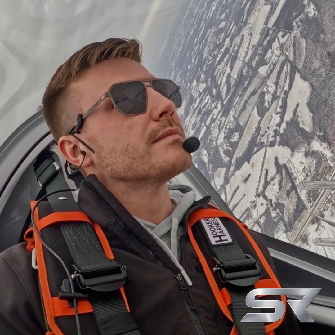 Pilot wearing SkyRift Vector titanium aviator sunglasses in cockpit. 